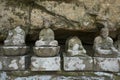 Row of broken old stone Buddha statues in Meganeiwa park, Sasebo