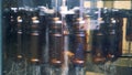 A row of brown plastic bottles is rotating and getting pasteurized