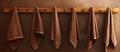 a row of brown towels hanging on a wooden rack