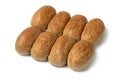 Row of of brown whole grain buns of bread close up on white background