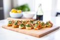 row of bruschetta on a ceramic platter with a small bowl of pesto sauce beside Royalty Free Stock Photo