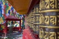 Row of Buddhist Prayer Wheels at a monastery Royalty Free Stock Photo