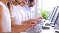 Row of call centre agents typing at their desk