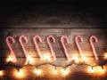 a row of candy canes and christmas lights toned with a retro vintage instagram filter effect