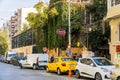 Row of cars parked along the side of a street surrounded by lush foliage and greenery in Turkey