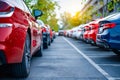 A row of cars are parked in a lot, with a red car in the middle. Generative AI Royalty Free Stock Photo