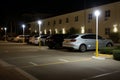 a row of cars parked in a parking lot at night