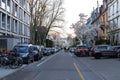 Row of cars parked on the sidewalk along a bustling city street