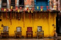 a row of chairs in front of a yellow building