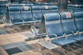 Row of chairs with social distancing signs at airport