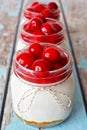 Row of cherry cheesecakes in mason jars