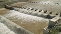 Row of chute dentate blocks in concrete water spillway channel slope slowing down the flow of water running down