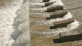 Row of chute dentate blocks in concrete water spillway channel slope slowing down the flow of water running down