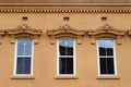 Row of city building windows with curved golden lintels Royalty Free Stock Photo