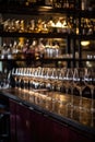 a row of clean, polished wine glasses hanging above a bar