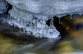 Row of clean transparent icicles hanging in cold forest creek water flow Royalty Free Stock Photo