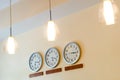 Row of clocks showing different time and lamps