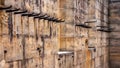 Row of coat wall hooks set in outside patio verandah historic sandstone school either side of windows