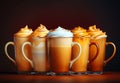 Row of coffee drinks with whipped toppings in glass mugs