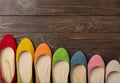 Row of colored shoes ballerinas on a dark wooden background. Royalty Free Stock Photo