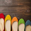 Row of colored shoes ballerinas on a dark wooden background. Royalty Free Stock Photo