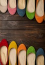 Row of colored shoes ballerinas on a dark wooden background. Royalty Free Stock Photo