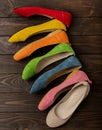 Row of colored shoes ballerinas on a dark wooden background. Royalty Free Stock Photo