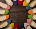 Row of colored shoes ballerinas on a dark wooden background. Royalty Free Stock Photo