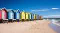 A row of colorful beach huts along a sandy shoreline with clear blue skies. Royalty Free Stock Photo