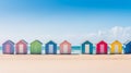 A row of colorful beach huts along a sandy shoreline with clear blue skies. Royalty Free Stock Photo