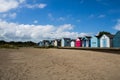 Row of colorful beach huts on a sandy beach on a sunny day Royalty Free Stock Photo