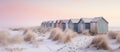 A row of colorful beach huts on sandy shore under clear sky Royalty Free Stock Photo