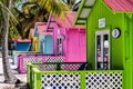 Row of colorful beach huts surrounded by palm trees. Royalty Free Stock Photo