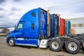 Row of the colorful big rigs semi truck tractors without semi trailers standing on the industrial parking lot waiting for the next Royalty Free Stock Photo