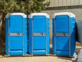 Row of colorful plastic portable restrooms Royalty Free Stock Photo