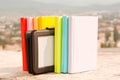 Row of colorful books with electronic book reader Royalty Free Stock Photo