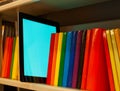 Row of colorful books and electronic book reader Royalty Free Stock Photo