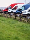 Row of colorful commercial vans in a dealership for sale or rent. Used and new busses. Transport industry. Selection of cargo