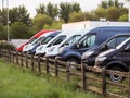 Row of colorful commercial vans in a dealership for sale or rent. Used and new busses. Transport industry. Selection of cargo