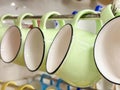 A row of colorful cups hanging on a rack