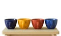 Row of colorful cups on wooden table Royalty Free Stock Photo