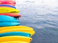 Row of colorful fiberglass kayaks in the sea