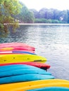 Row of colorful fiberglass kayaks in the sea