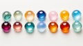 Row of colorful glass spheres on white surface, reflecting light. Concept of glass art, marbles collection, color Royalty Free Stock Photo