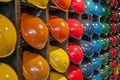 row of colorful helmets displayed on wallmounted racks