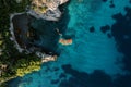 Row of colorful kayaks lined up in the sea opposite the rocky shore. Top view Royalty Free Stock Photo