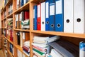 Row of colorful office folders with blank white labels on shelf Royalty Free Stock Photo