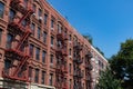 Row of Colorful Old Brick Apartment Buildings in Harlem of New York City with Fire Escapes Royalty Free Stock Photo