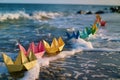 row of colorful paper ships on the shore with waves Royalty Free Stock Photo