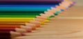 Row of colorful pencils rainbow order on wooden table